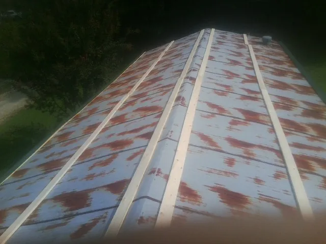 Rusted metal roof panels with new wood purlins before replacement — Storm Damage Roof Repair in Helper by Roofing Brothers