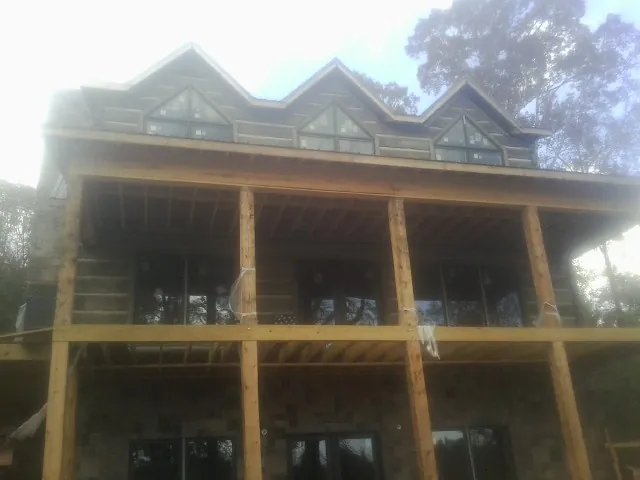Dormers and porch framing on a large log home under construction — Roof Coating work by our crew in Helper