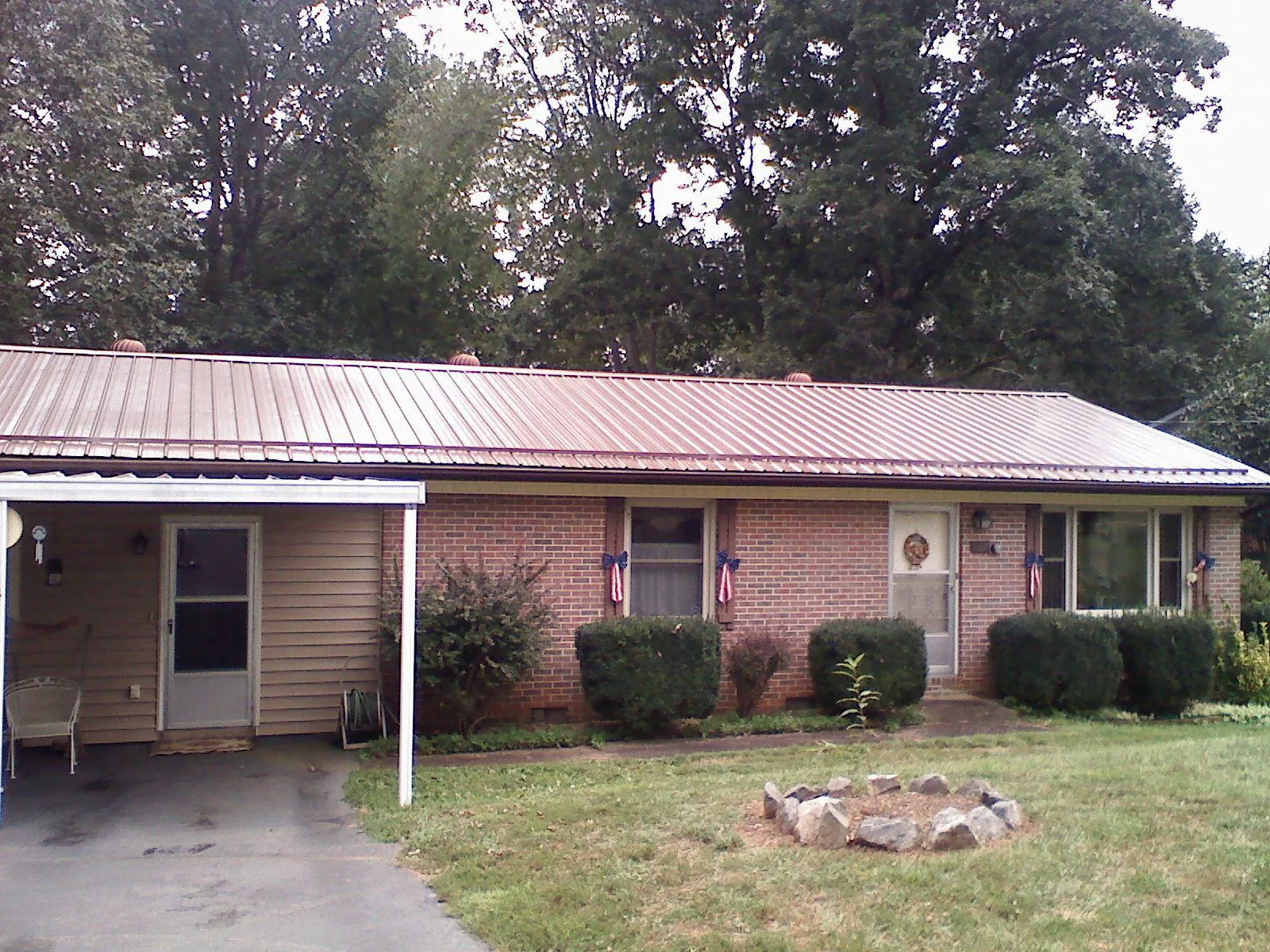 Bronze metal roof and carport on a brick ranch home — Roof Repair work by our crew in Helper